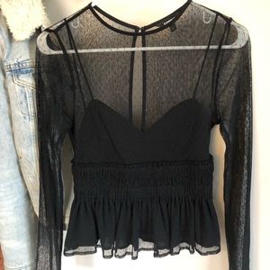 Sheer black peplum top with black under tank .